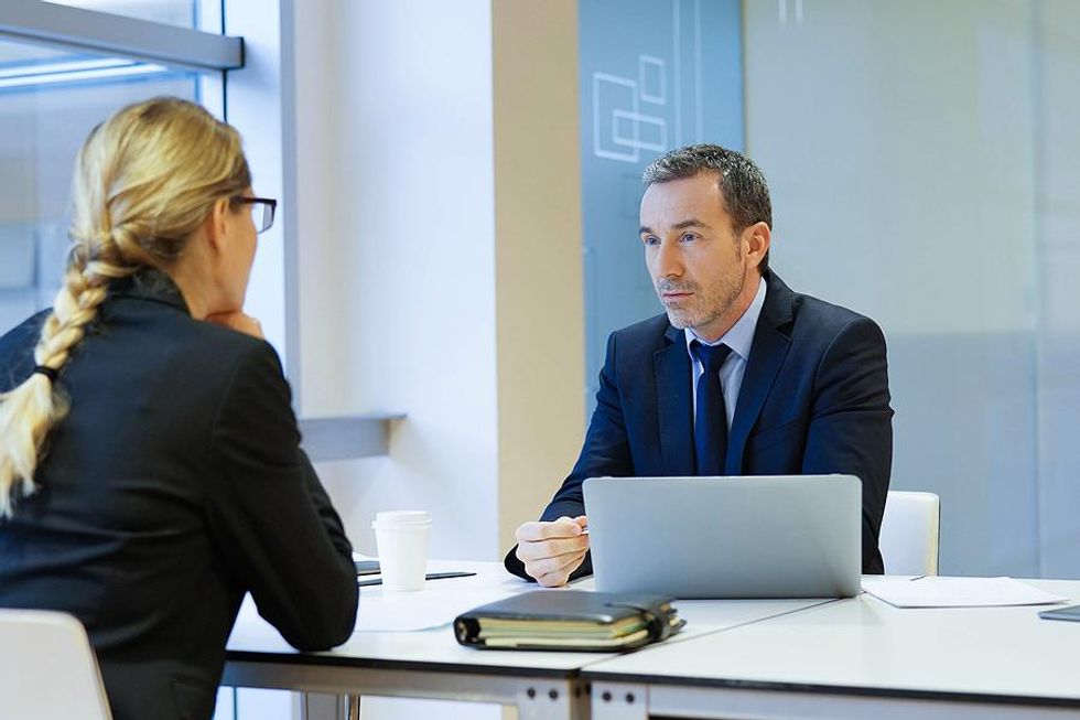 Manager looks at his colleague during a salary negotiation meeting