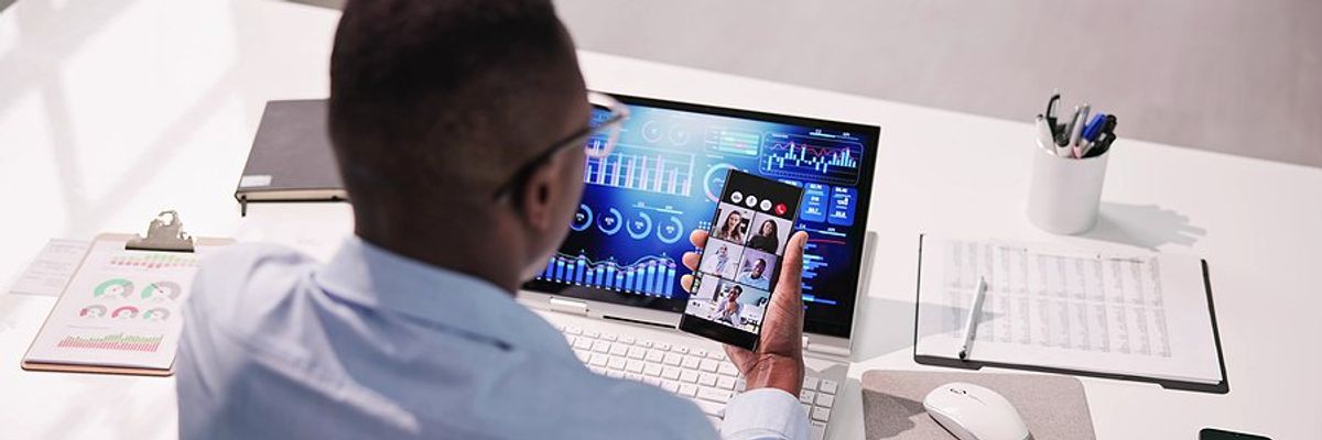 Manager looks at KPI dashboard while on a video call with his coworkers