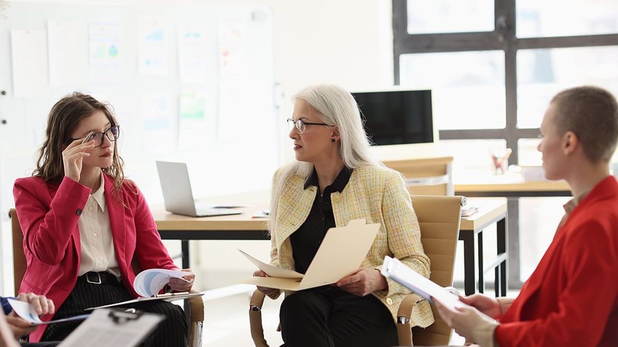 Manager talks to laid-off employees about outplacement services in a meeting