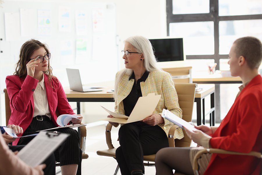 Manager talks to laid-off employees about outplacement services in a meeting