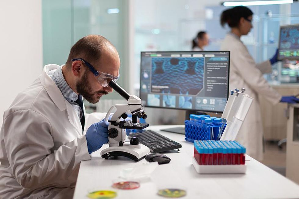 Molecular biologist looking at a slide with a microscope