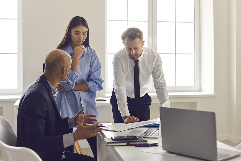 New manager discusses an issue with two employees during a meeting