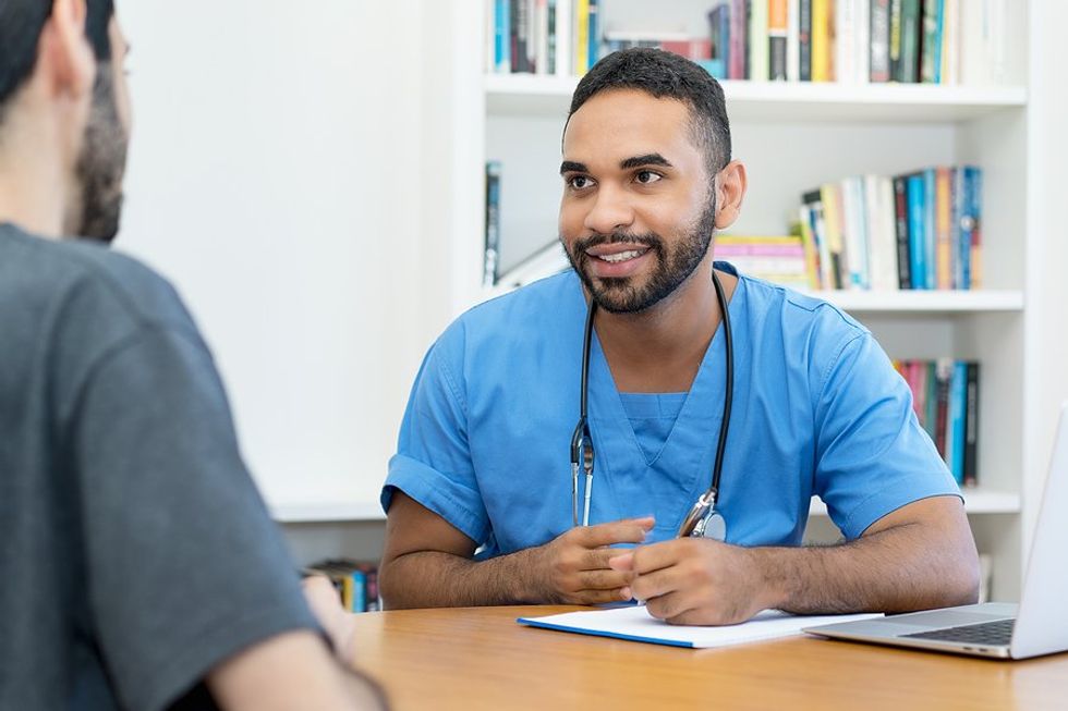 Nurse/doctor/healthcare professional talks to a patient