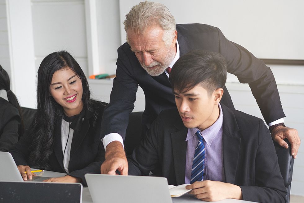Older executive mentors two young professionals