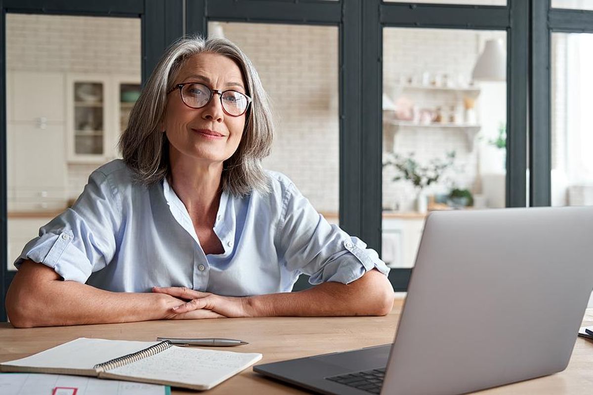 Older professional smiles while taking actions to stay relevant in her career