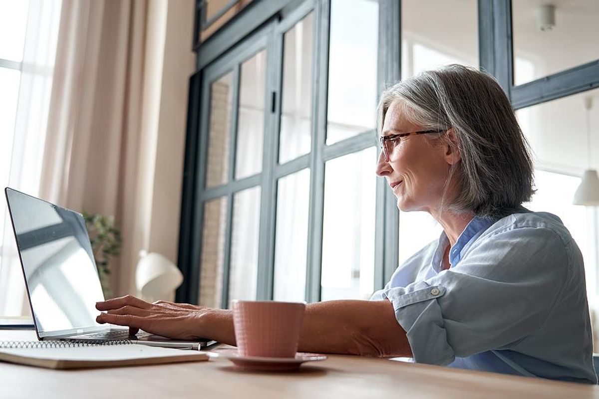 Older professional typing on laptop