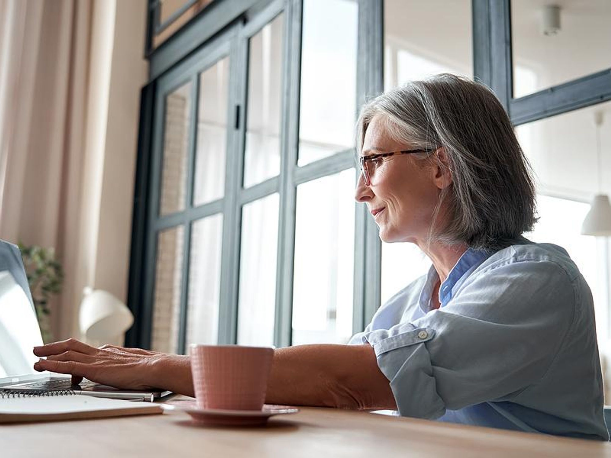 Older professional typing on laptop