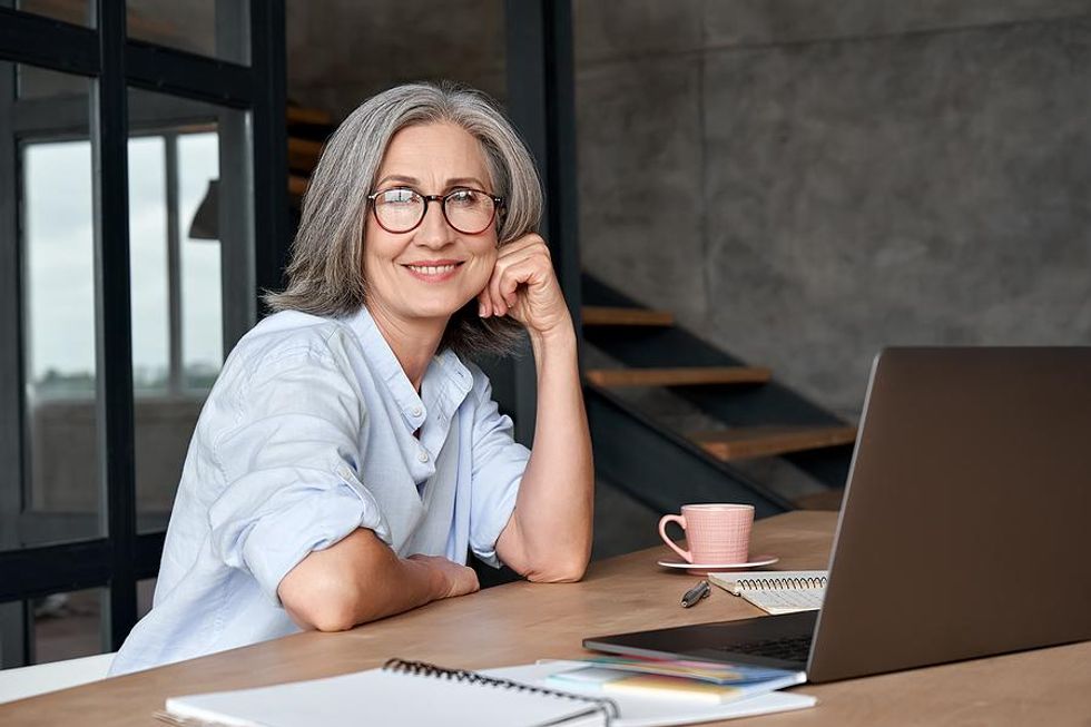 Older woman on laptop happy in her career