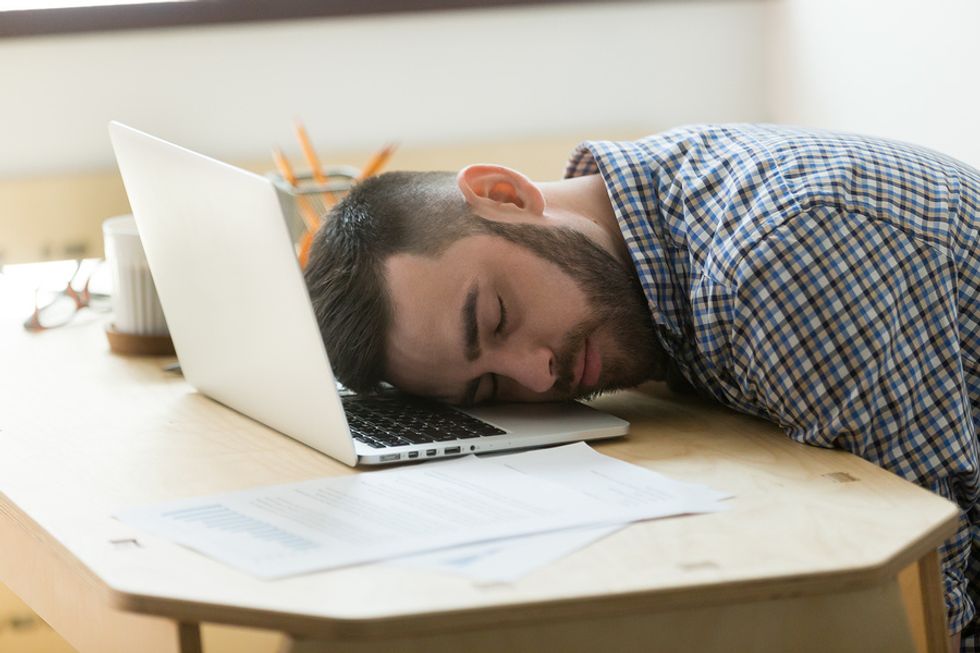 Overworked man exhausted at work