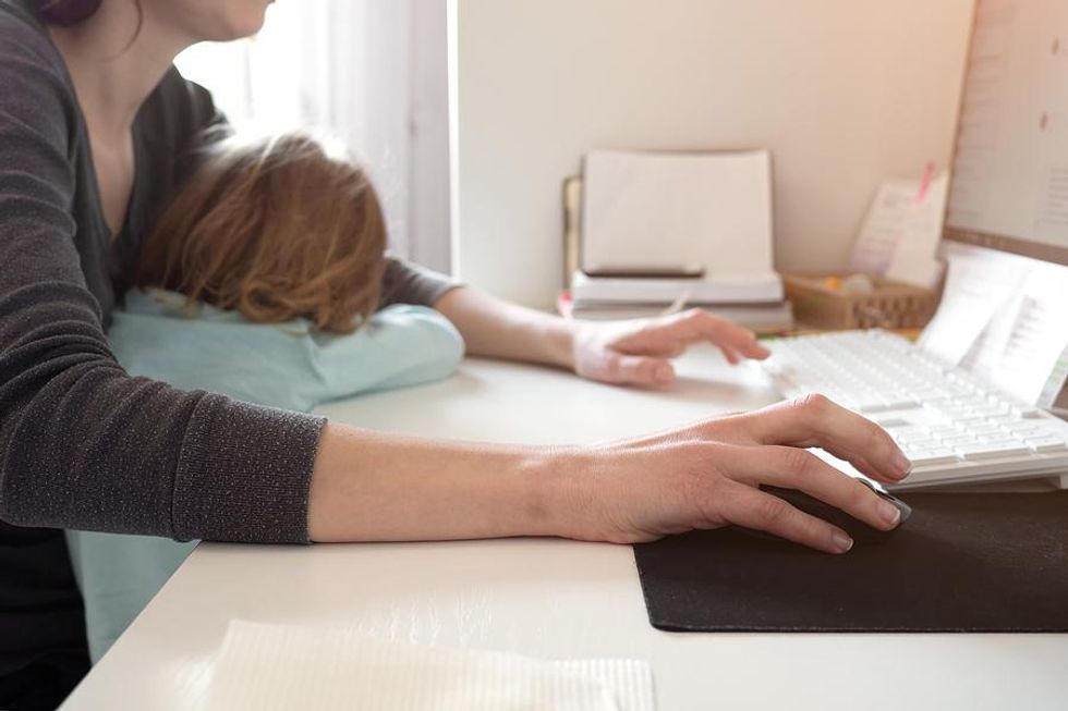 Parent comforts child while working from home