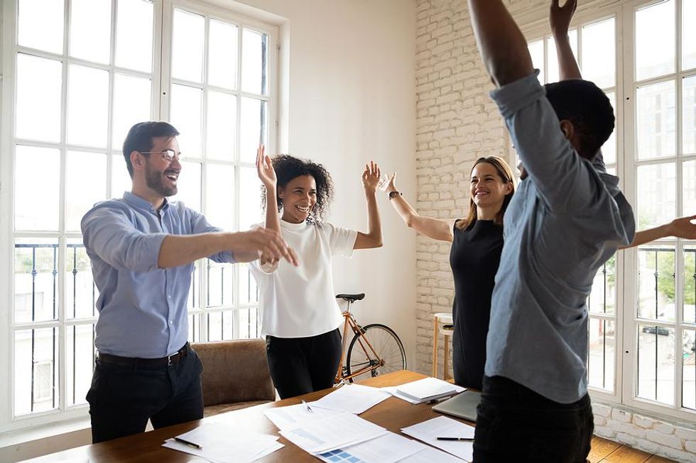 Active employees celebrate their success in a work meeting