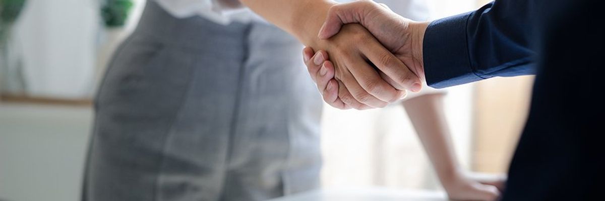 Professional/business person shakes hands with a key stakeholder