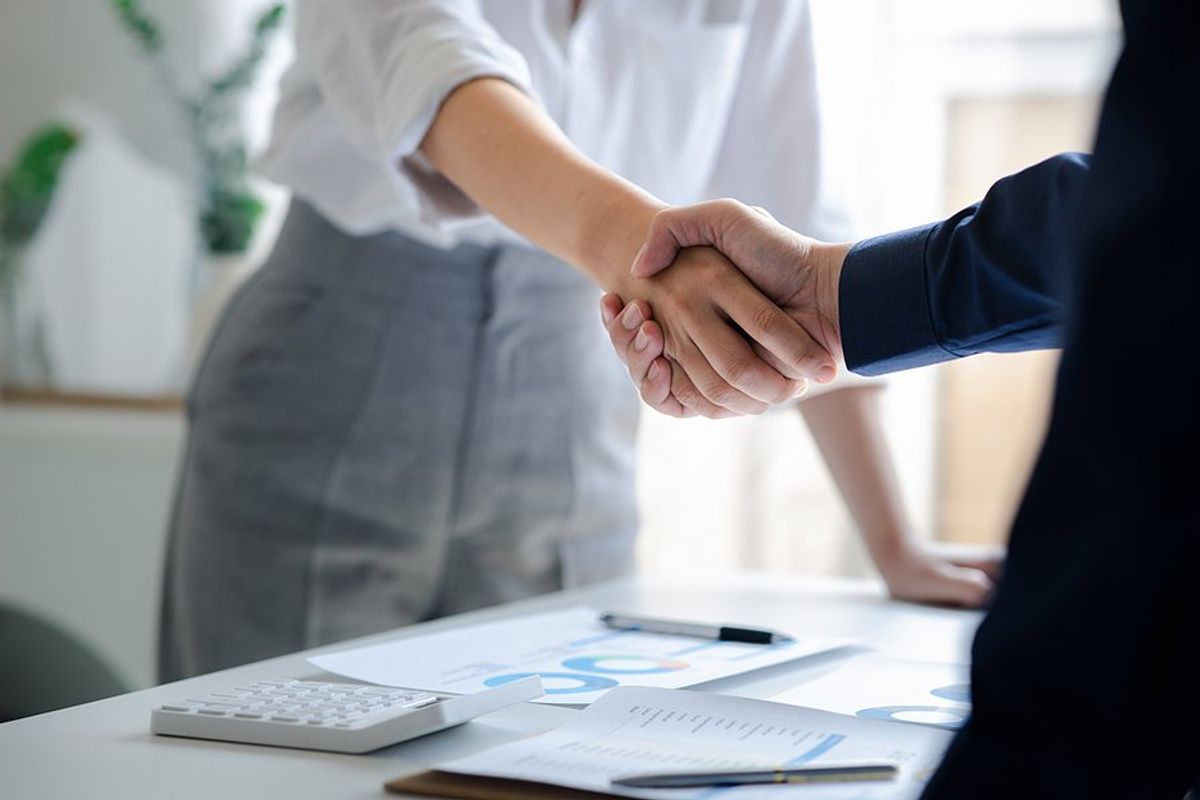 Professional/business person shakes hands with a key stakeholder