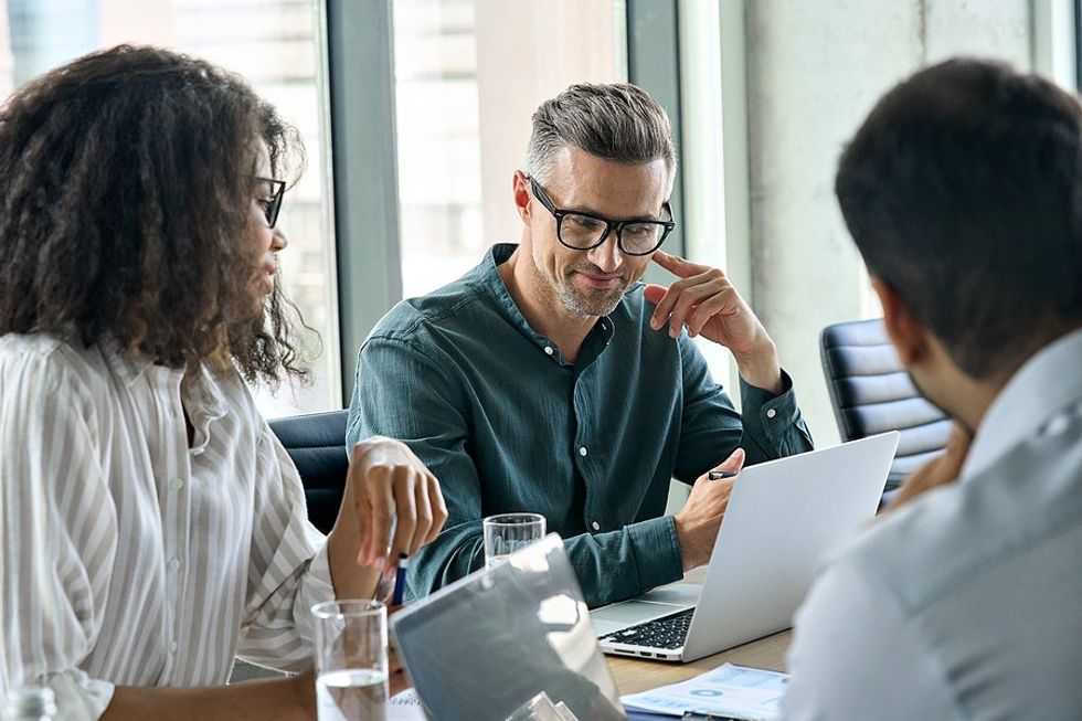 Professional/leader listens to a coworker during a work meeting