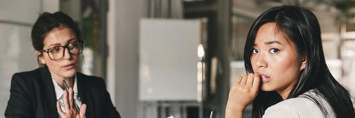 Professional looks nervous during a serious career discussion with her boss.