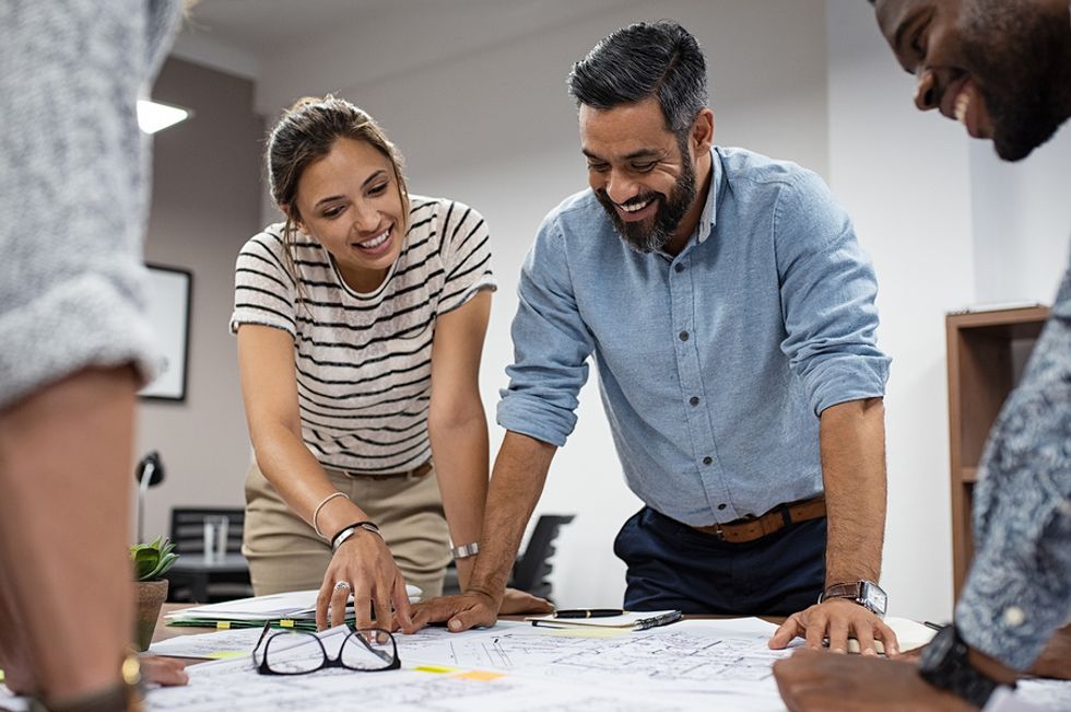 Professional man and professional woman smiling while going over a work project they are passionate about.