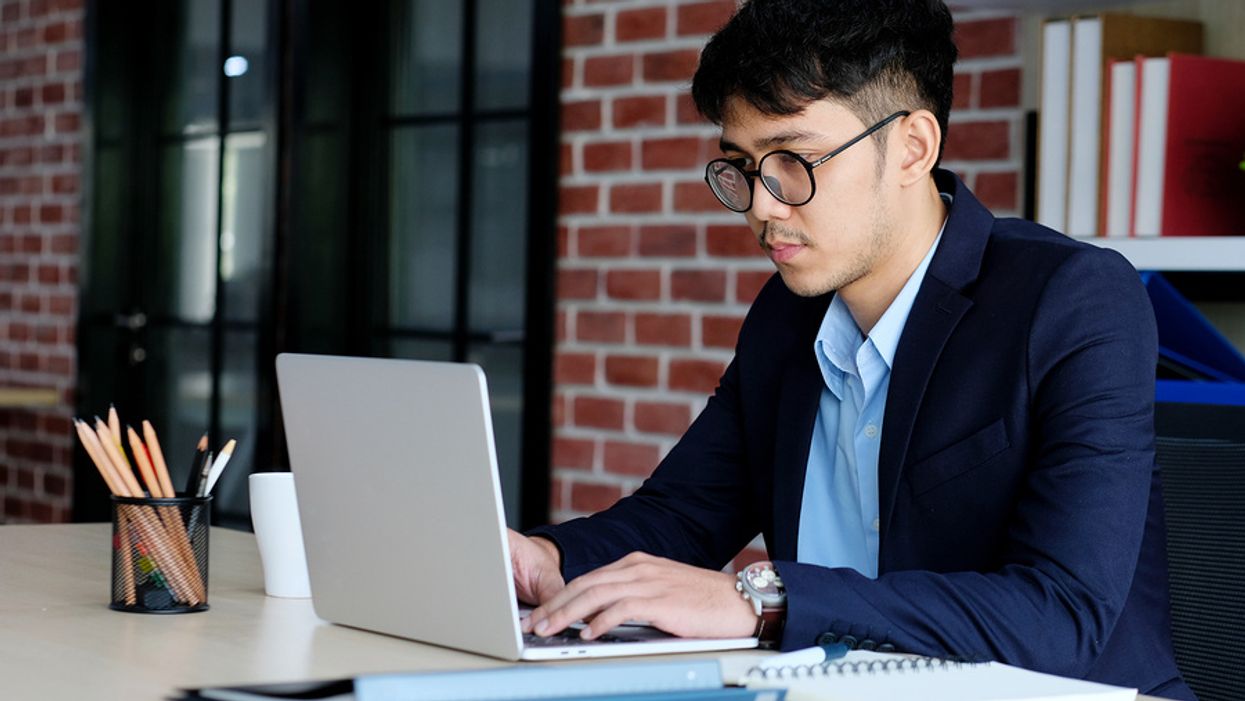 Professional man on laptop answers salary questions on a job application