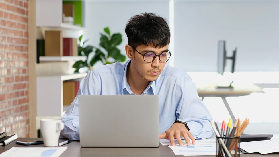 Professional man on laptop looks for problems to solve at his company