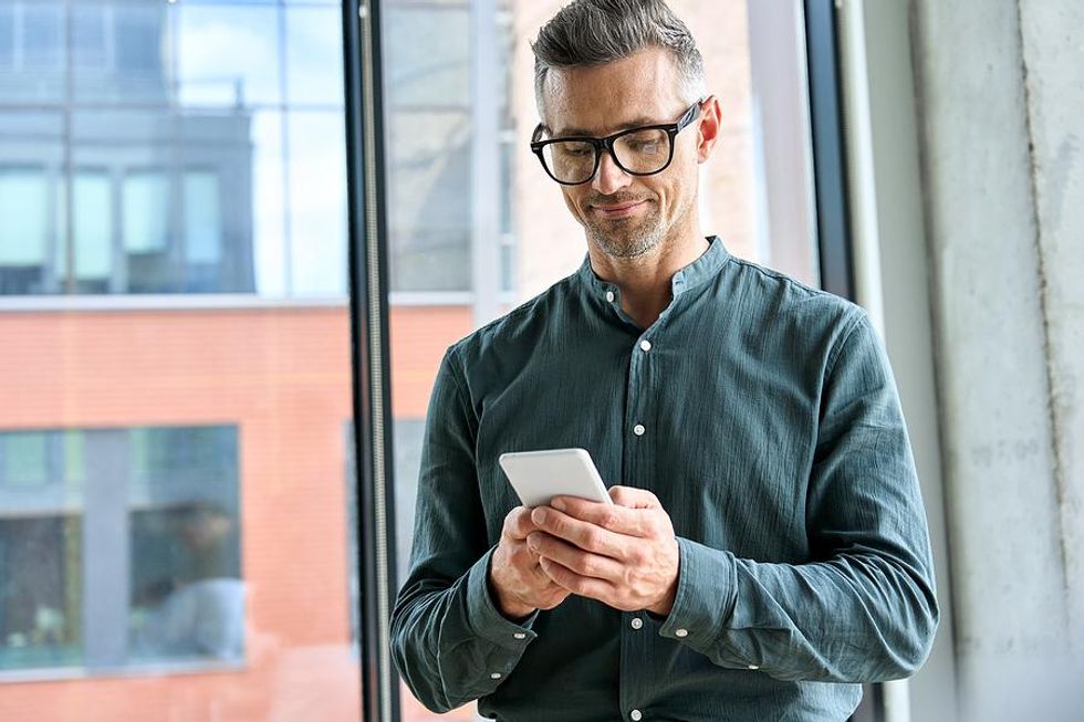 Professional man on phone uses LinkedIn for networking