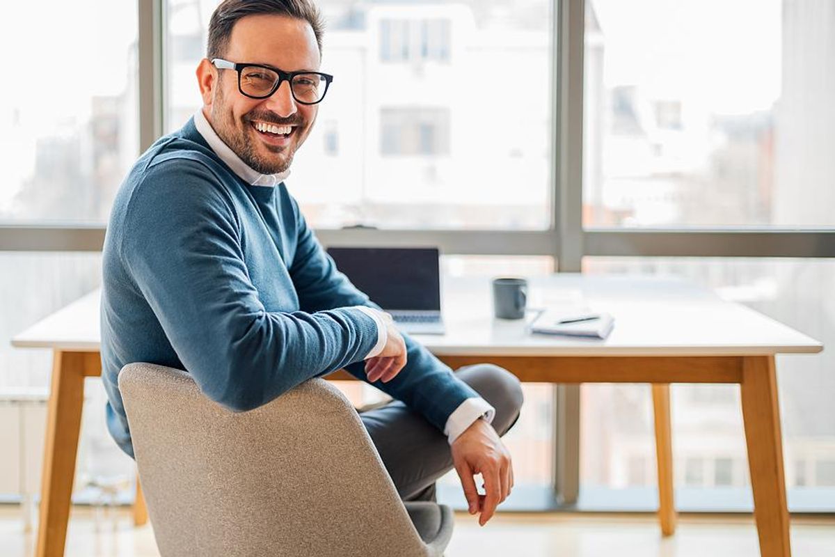 Professional man smiles at his desk