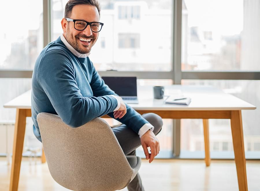 Professional man smiles at his desk