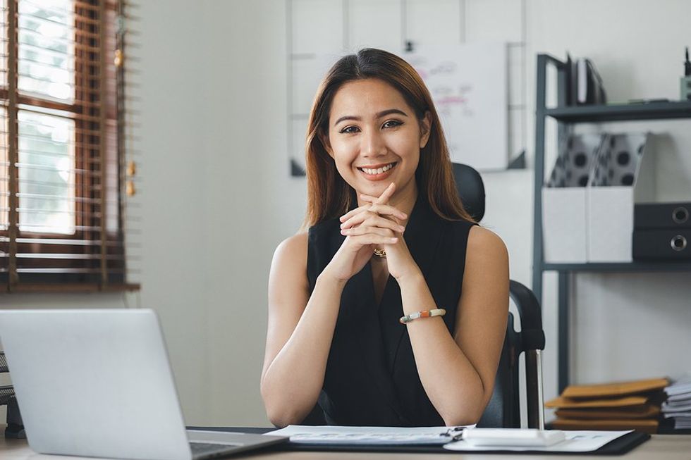 Professional woman/executive/leader with good professional presence sits at her desk