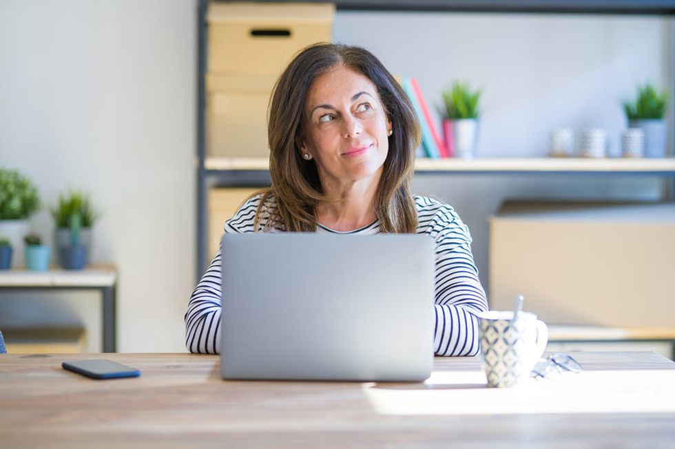 Professional woman on laptop thinking about her career regrets