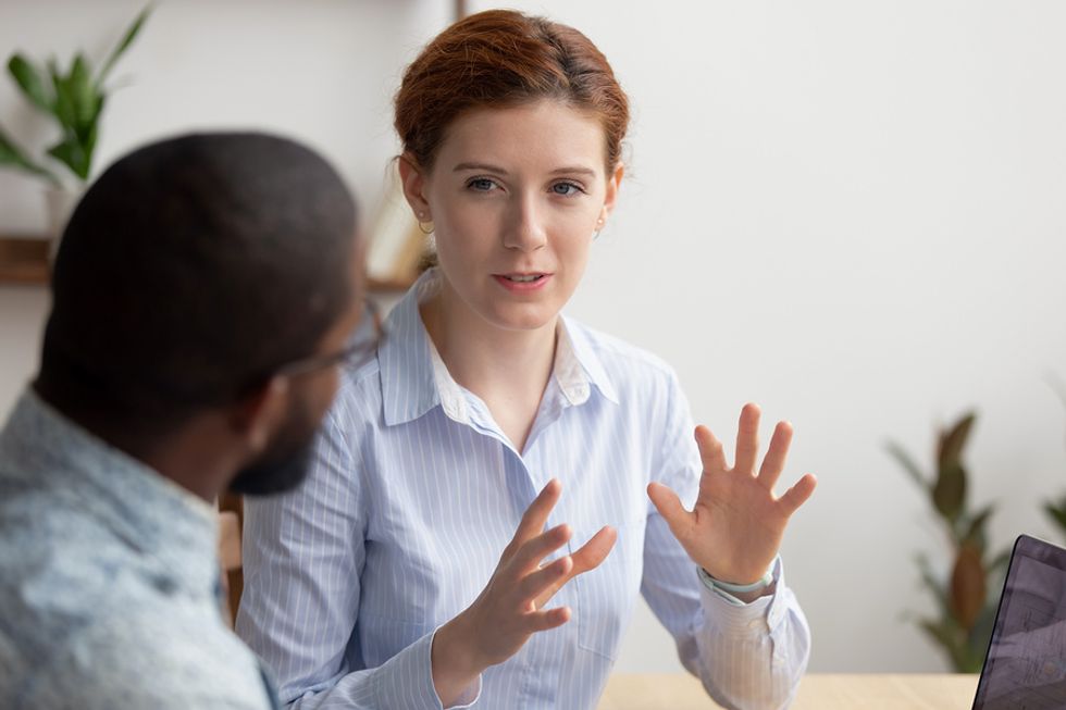 Professional woman talks to her boss about becoming an indispensable employee at work