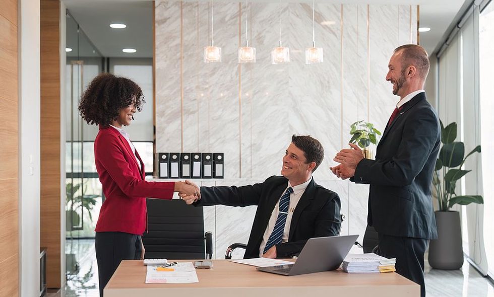 Professional woman with good business etiquette shakes hands with a business partner
