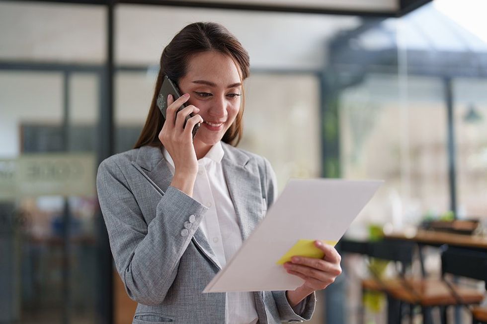 Professional woman with good time management skills calls someone on the phone