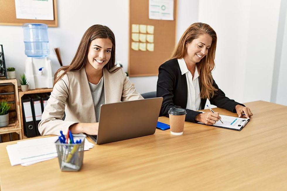 Professional women smile as they work