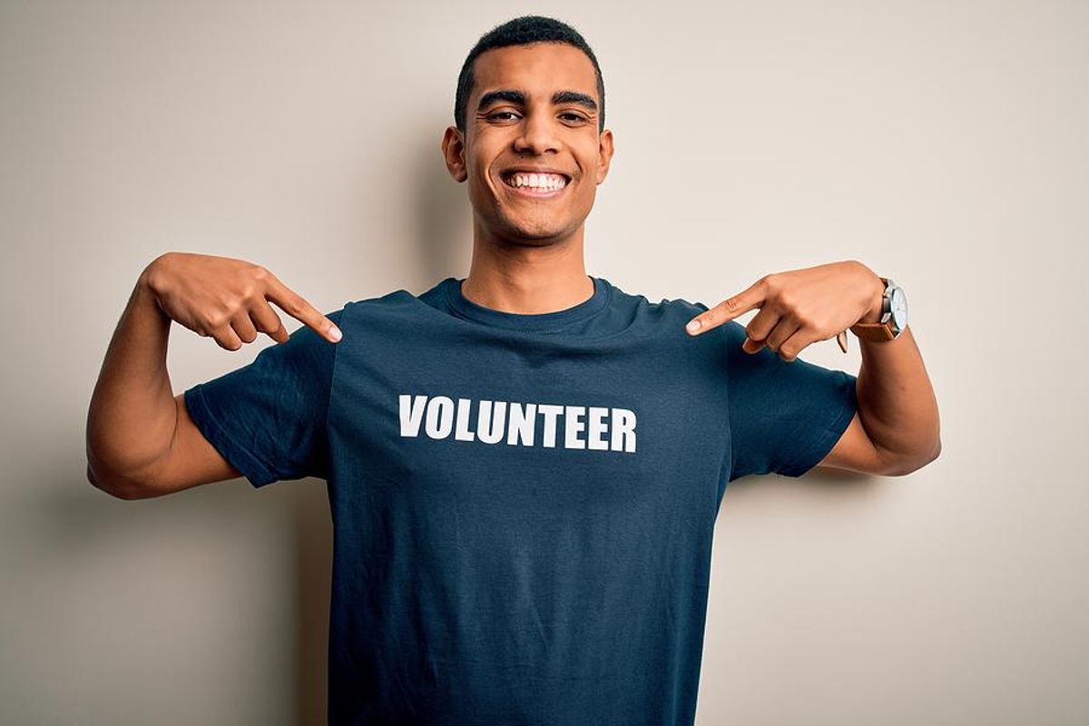 Proud volunteer points to his shirt