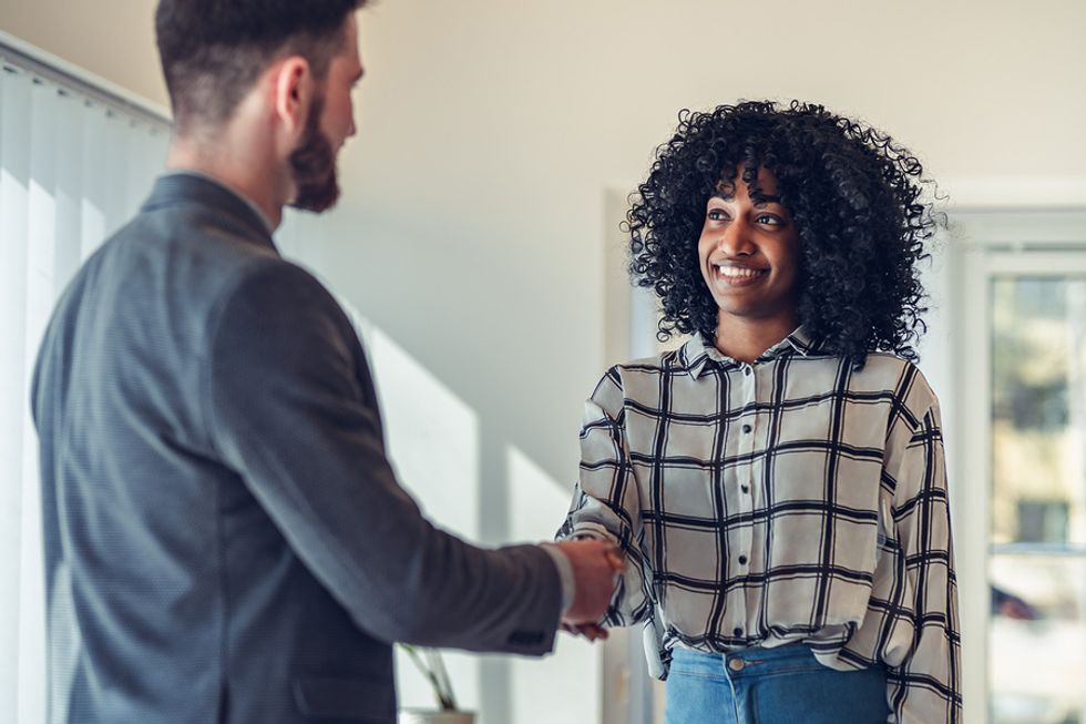 Recent college grad shakes hands with the hiring manager