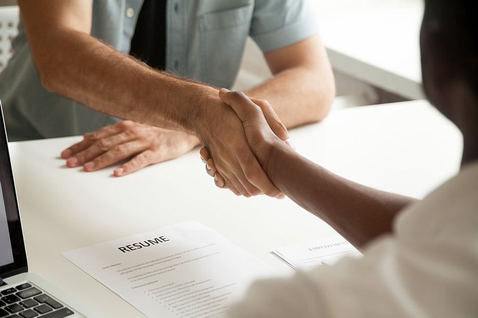 Recruiter / hiring manager shakes hands with a job candidate before a job interview