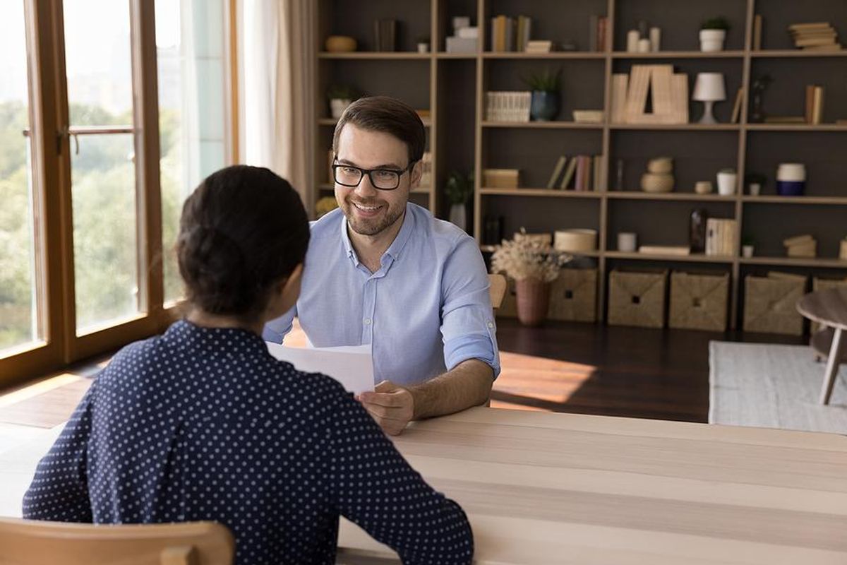 Recruiter holds a job candidate's resume and cover letter during an interview