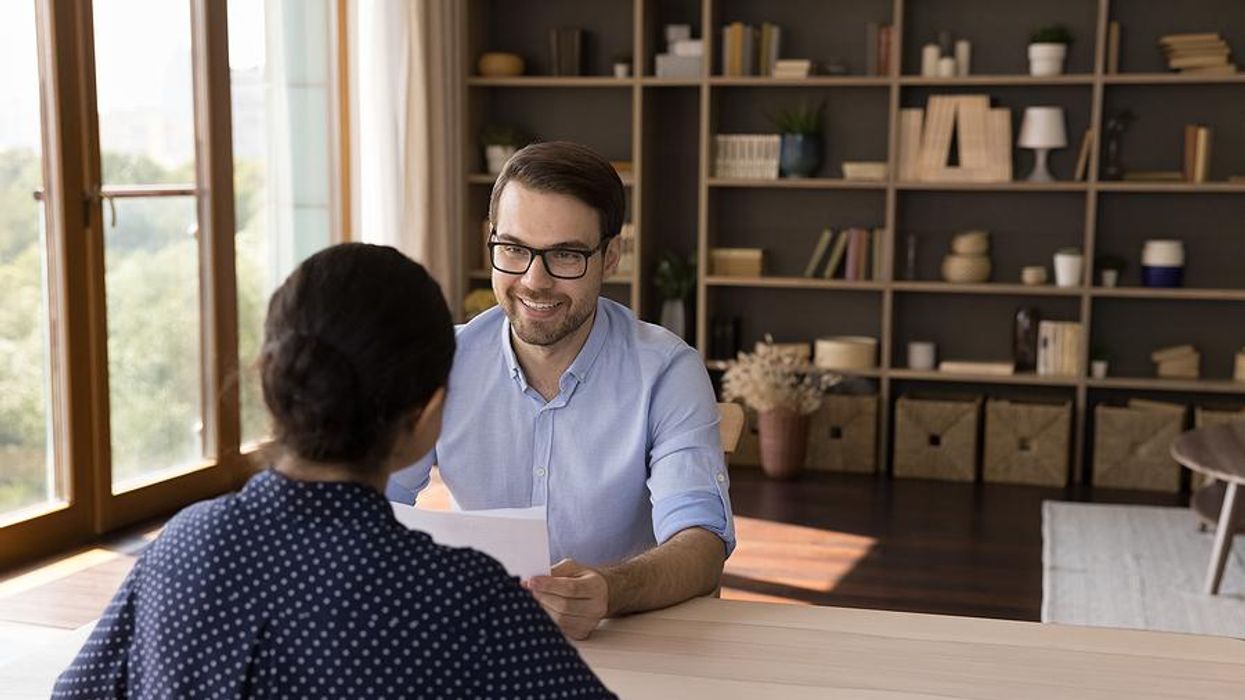 Recruiter holds a job candidate's resume and cover letter during an interview