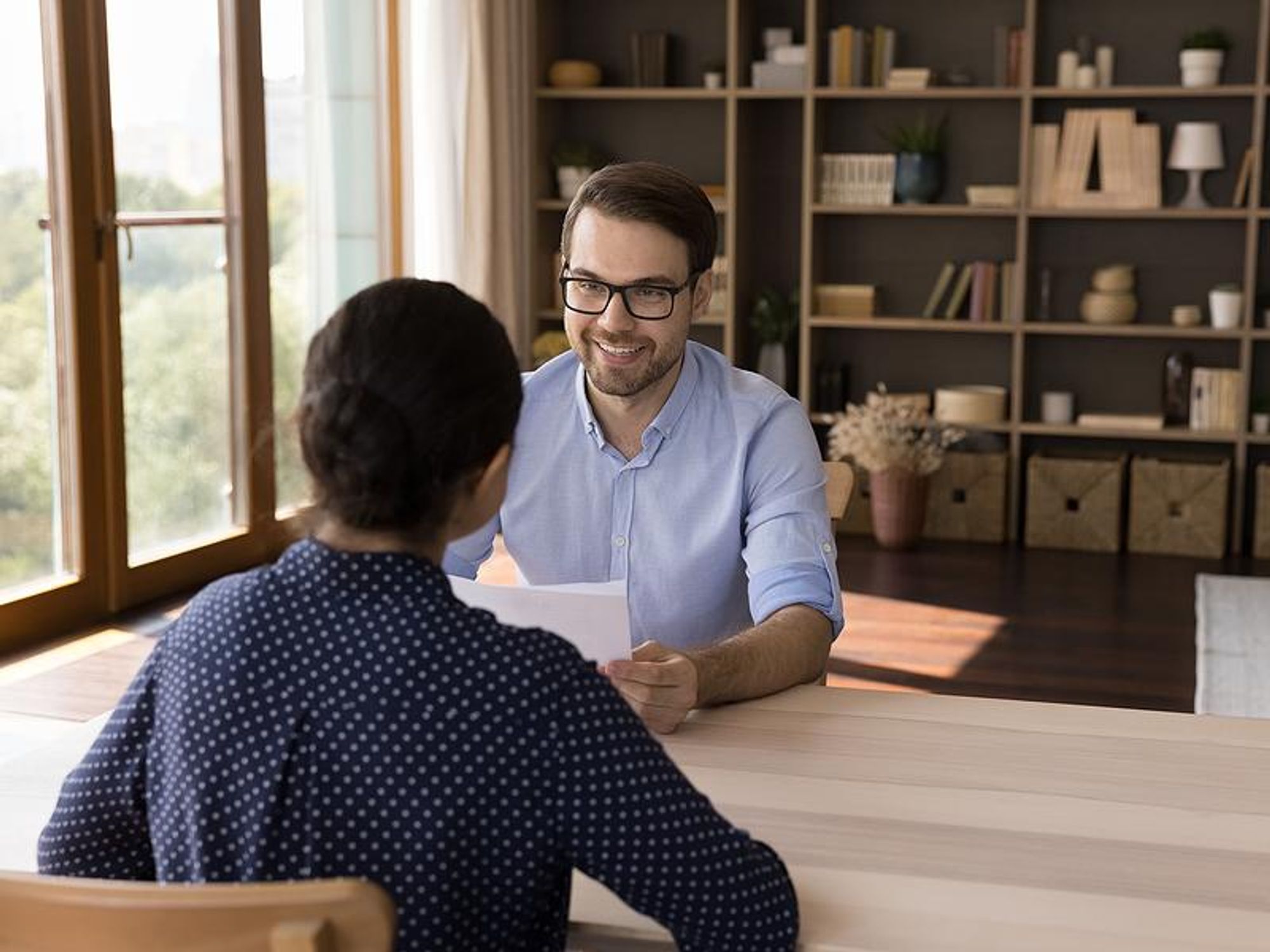 Recruiter holds a job candidate's resume and cover letter during an interview