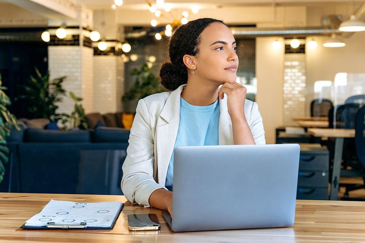 Recruiter on laptop thinks about how she can fill a role in an unfamiliar industry
