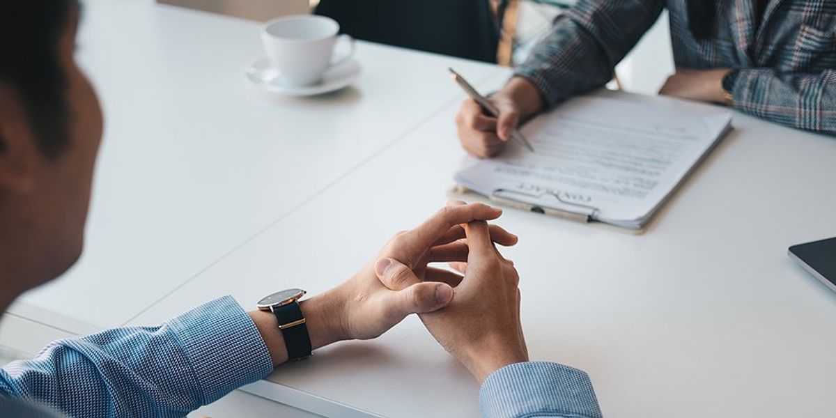 Recruiter reads a job candidate's impressive resume during a job interview