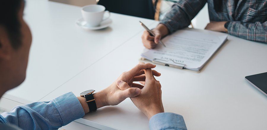 Recruiter reads a job candidate's impressive resume during a job interview