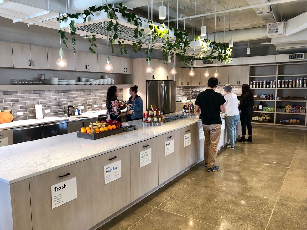 SeatGeek employees take a break from work to chat and enjoy some food in the company kitchen.