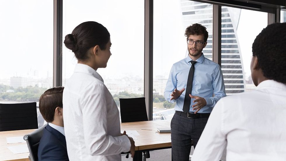 Serious leader shares difficult news with employees at work