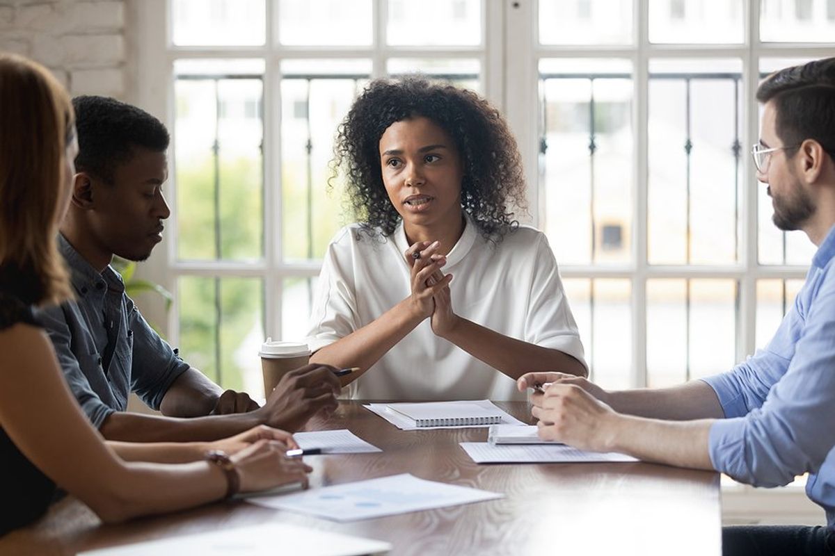 Serious leader shares difficult news with employees during a work meeting
