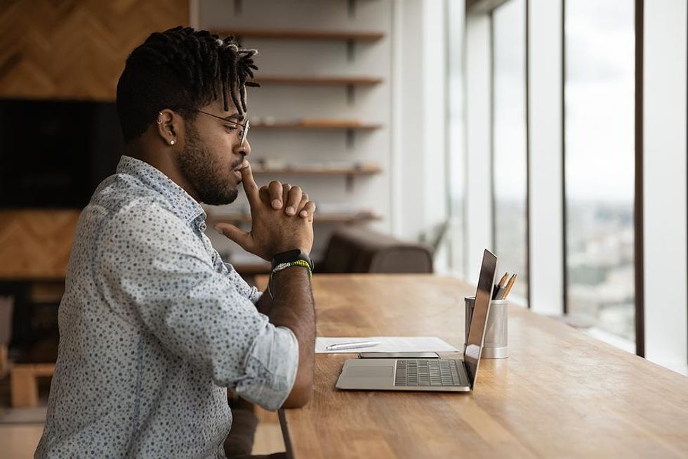 Serious man on laptop looks for a job