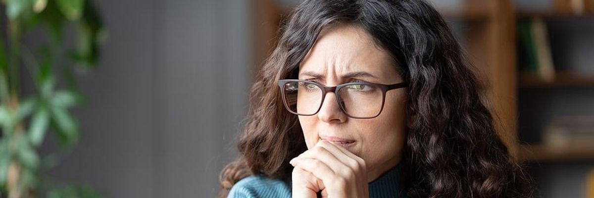 Serious/stressed/anxious woman on laptop thinking about a recession