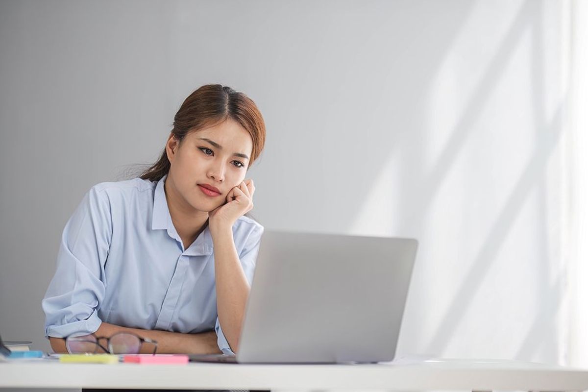 Serious woman on laptop saw the job she interviewed for was reposted