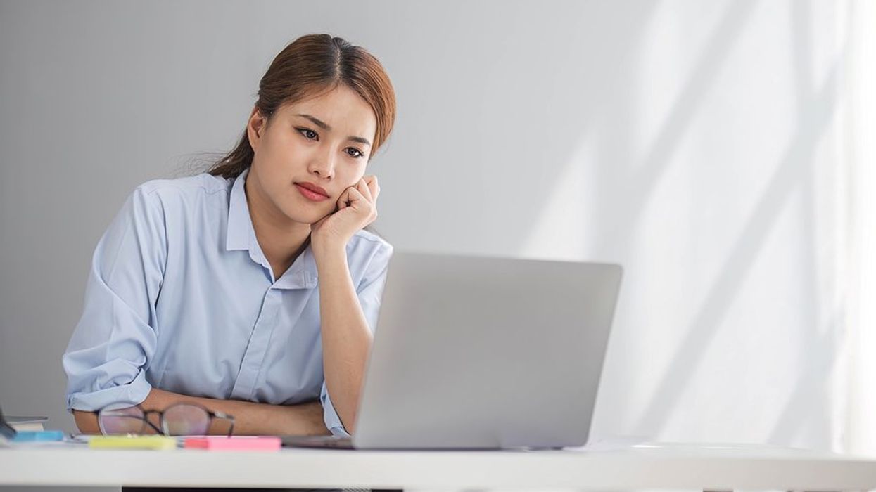 Serious woman on laptop saw the job she interviewed for was reposted