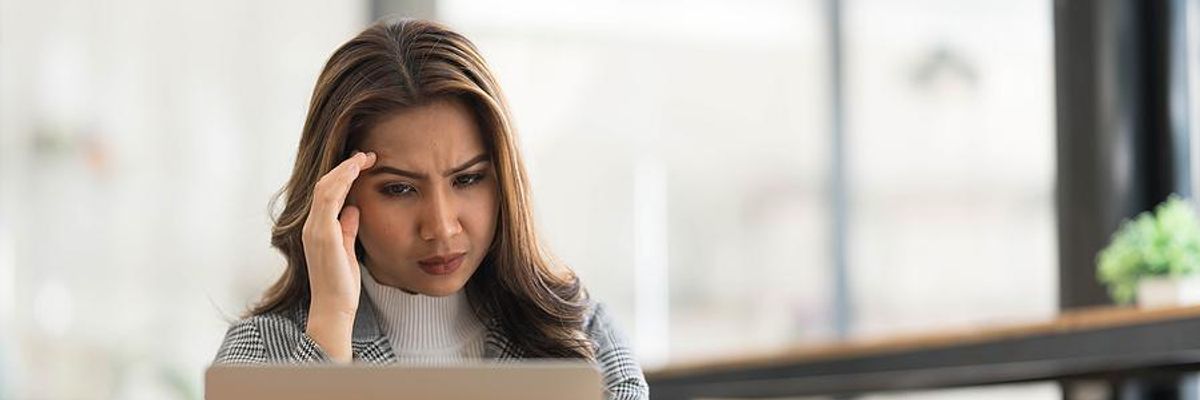Serious woman on laptop thinks about changing careers