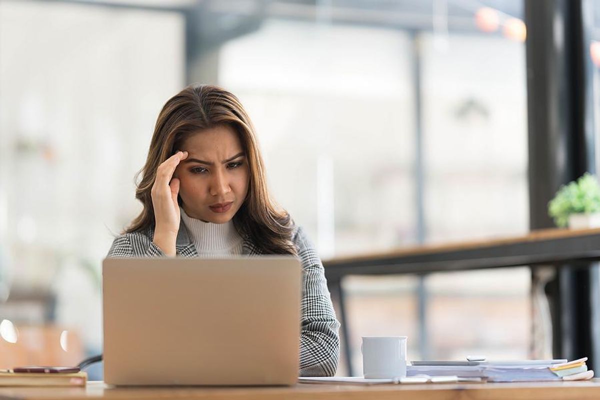 Serious woman on laptop thinks about changing careers