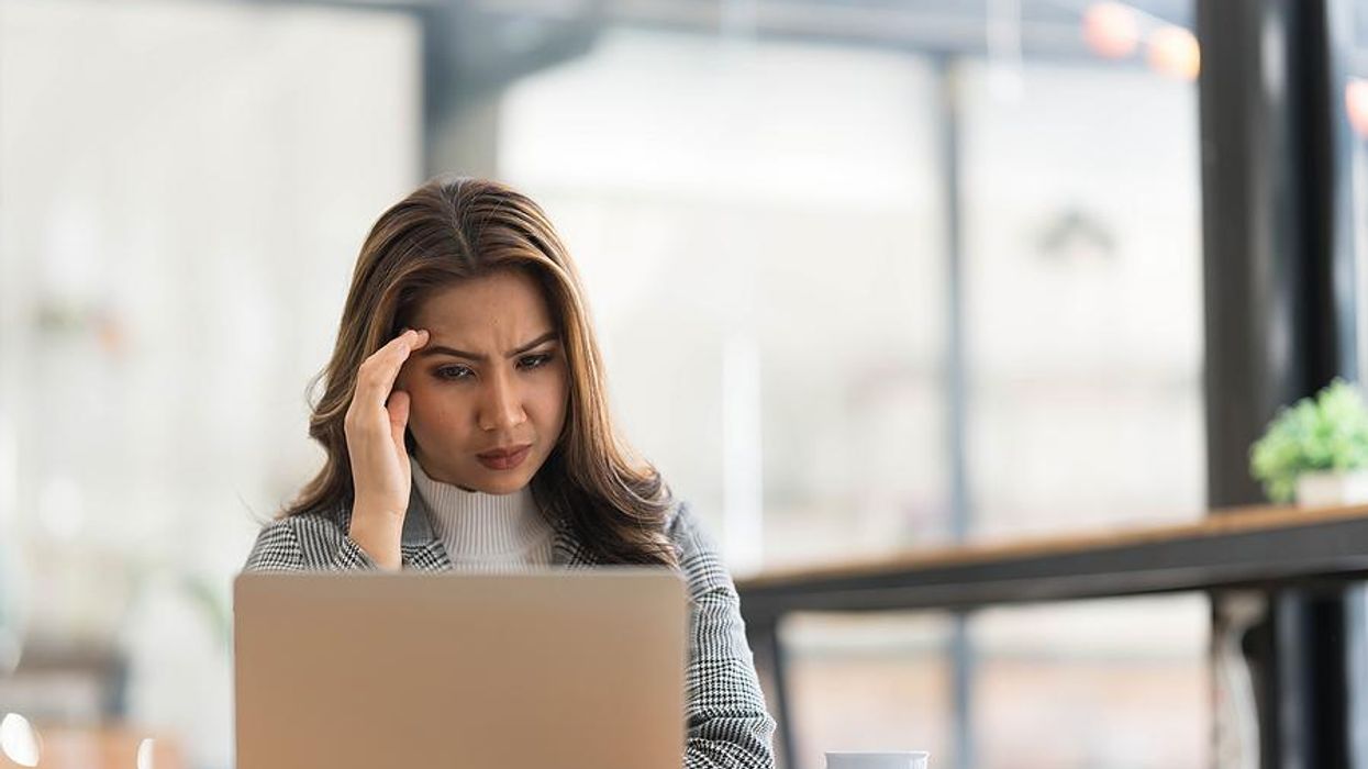 Serious woman on laptop thinks about changing careers